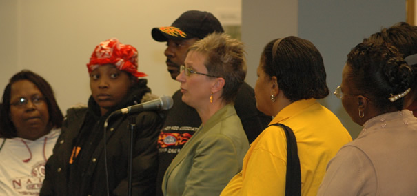 October 24, 2007. Jeannie Nowaszewski (above, with glasses at microphone) of the Board’s Office of New Schools was called on to explain why her department had not informed the members of the Parker Elementary School Local School Council that “New Schools” was recommending the placement of a charter school inside Parker. What Nowaczewski didn’t mention — and what the Parker parents (above) weren’t told — was that the Board has been placing charter schools inside existing public schools since 2002. Once the charters are inside the existing public schools, they begin a process called “eating them alive from the inside” slowly, as one critic has put it. Charters have devoured Howland, Wadsworth and other public schools since Arne Duncan began promoting charters at the expense of real public schools more than  five years ago. Photo by George N. Schmidt.